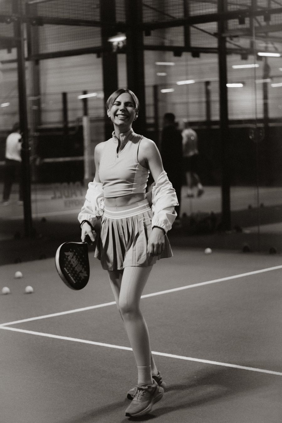Padel player walking across an indoor court